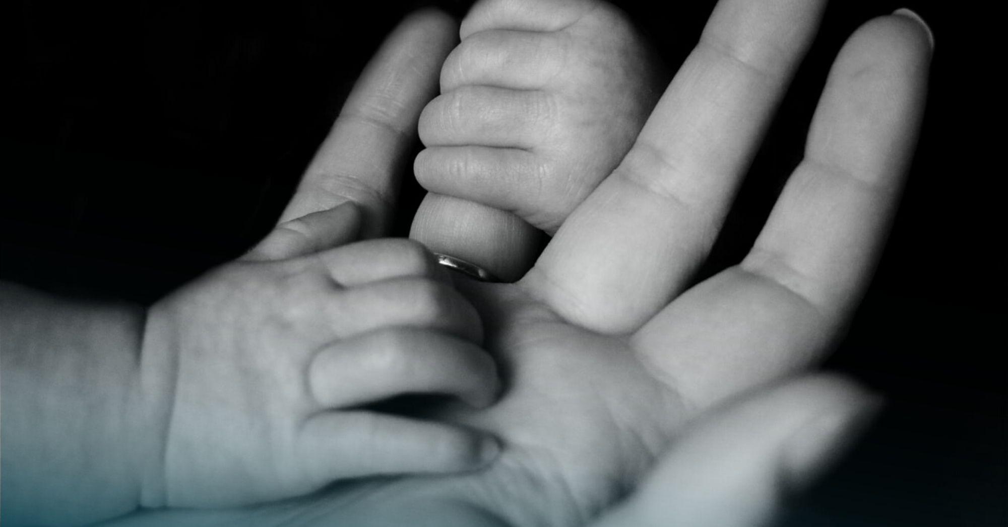 Baby holding mother's hand